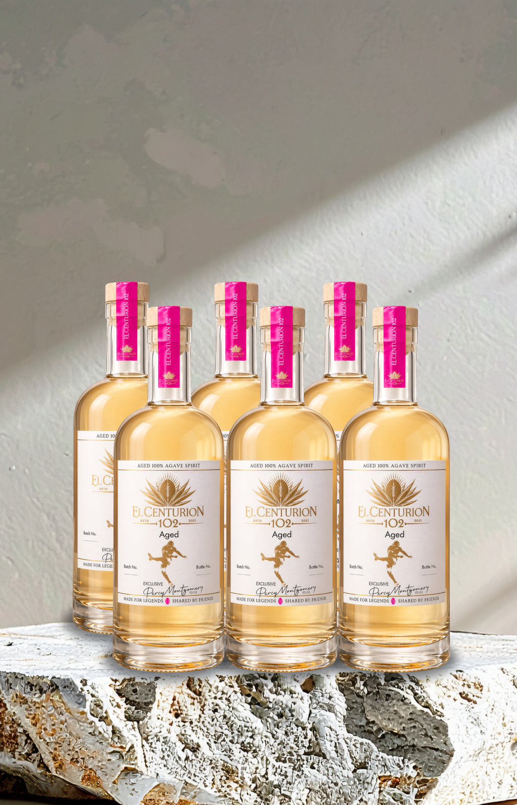 Six bottles of El Centurion 102 with pink labels on a stone surface.