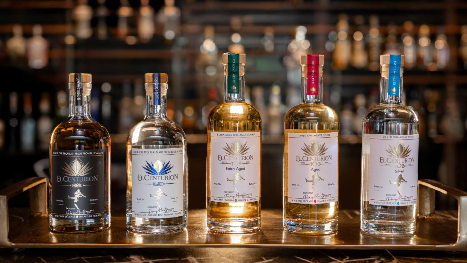Five bottles of El Centurion 102 Agave Spirit on a bar shelf with blurred background