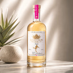 Bottle of El Centurion 102 agave spirit on a reflective surface with a plant in the background