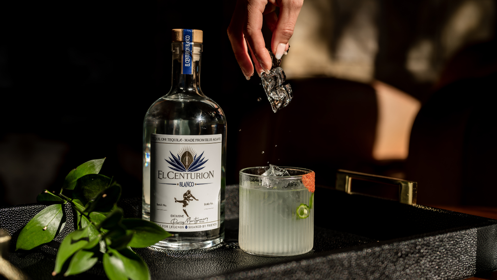 Bottle of El Centurion blanco with a cocktail being prepared on a bar.