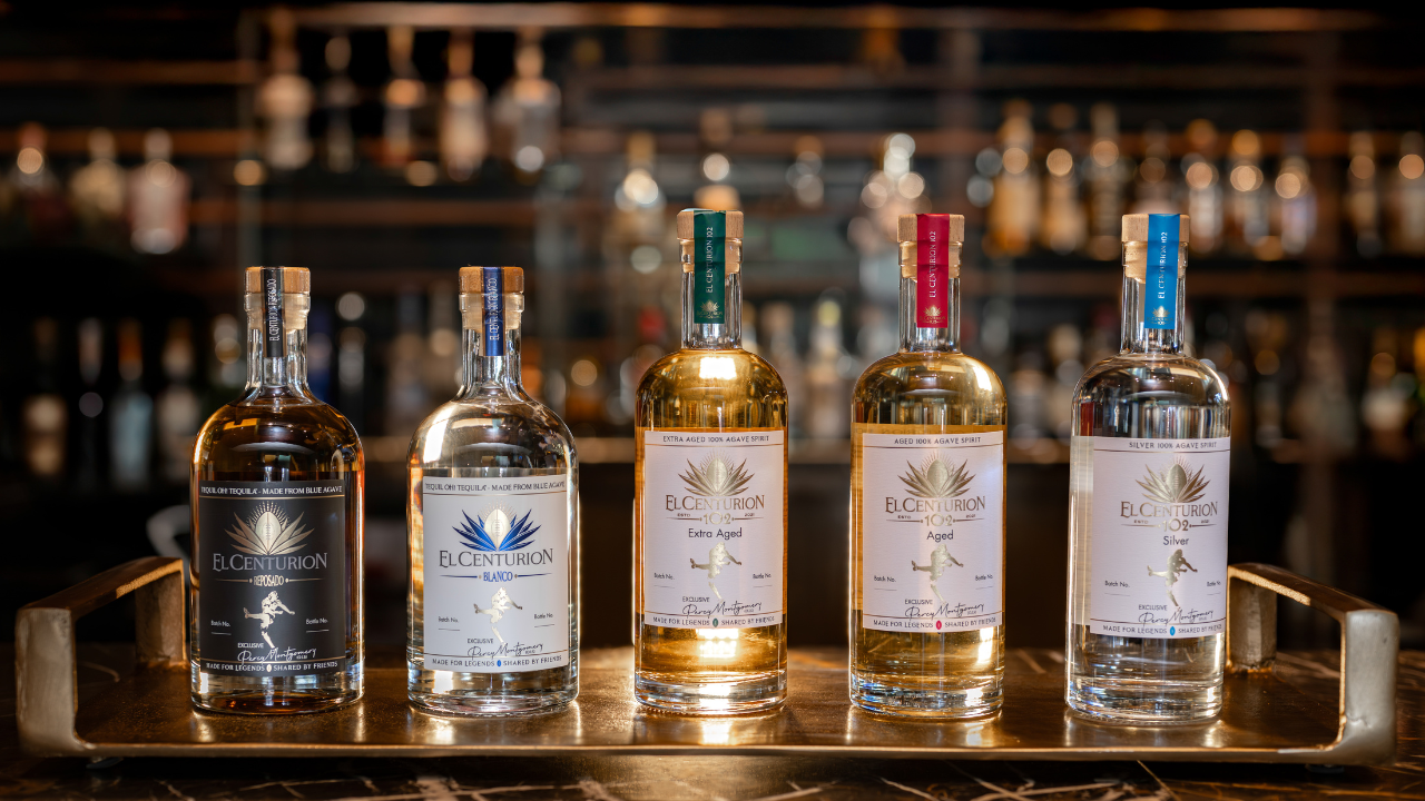 Five bottles of Eclipsed spirits on a bar tray with a blurred bar background