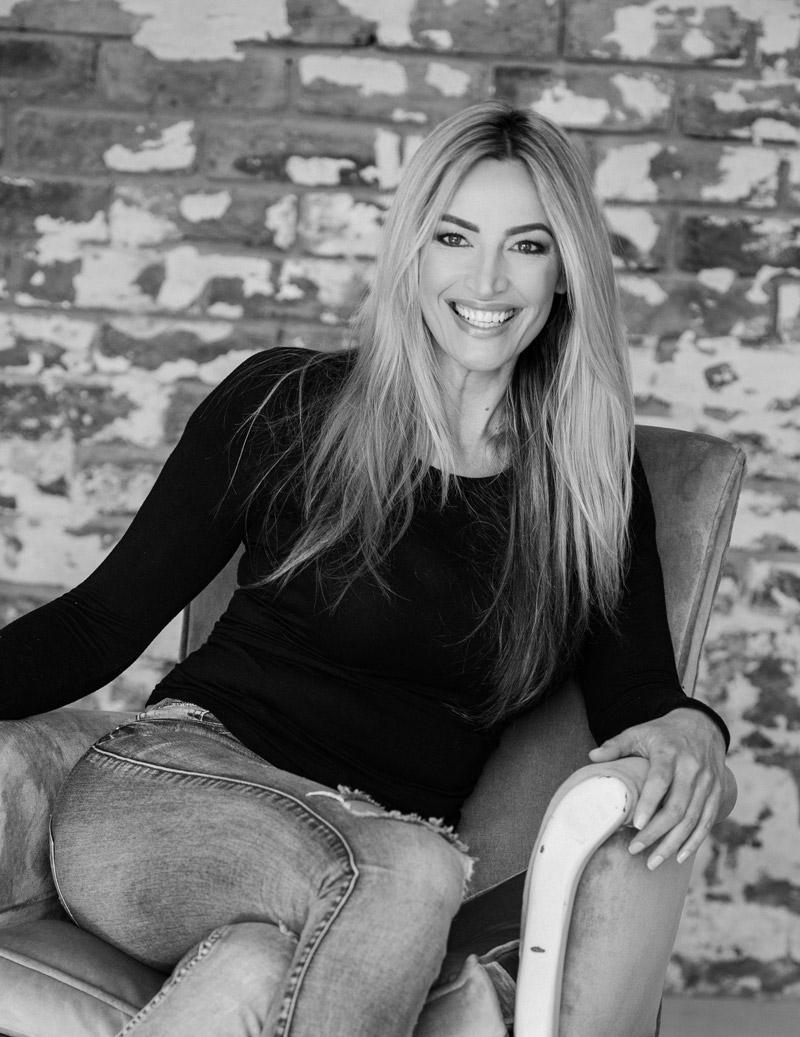 Woman sitting on a chair against a brick wall background